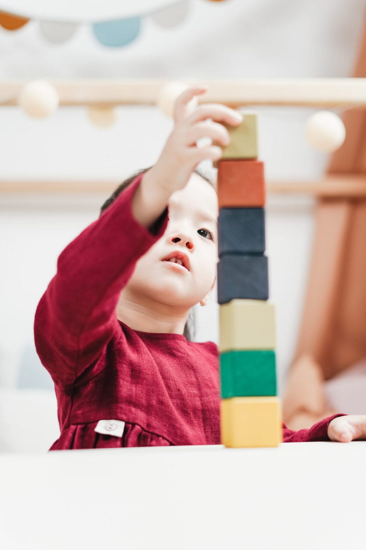 Image of a young child stacking blocks as high as possible