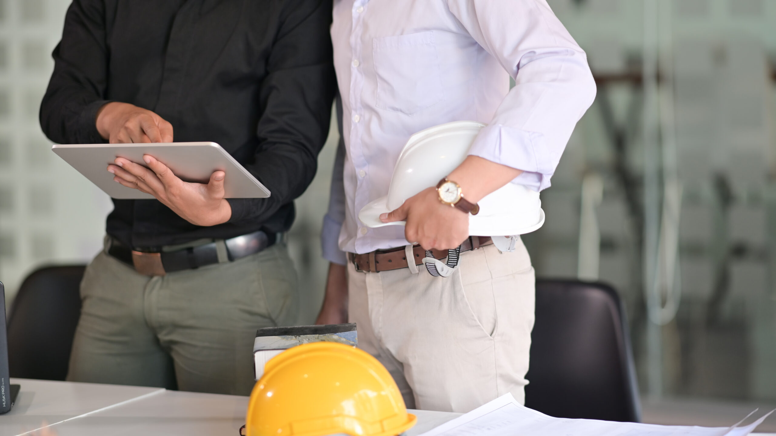 Image of a laptop with various construction equipment around for budget control software