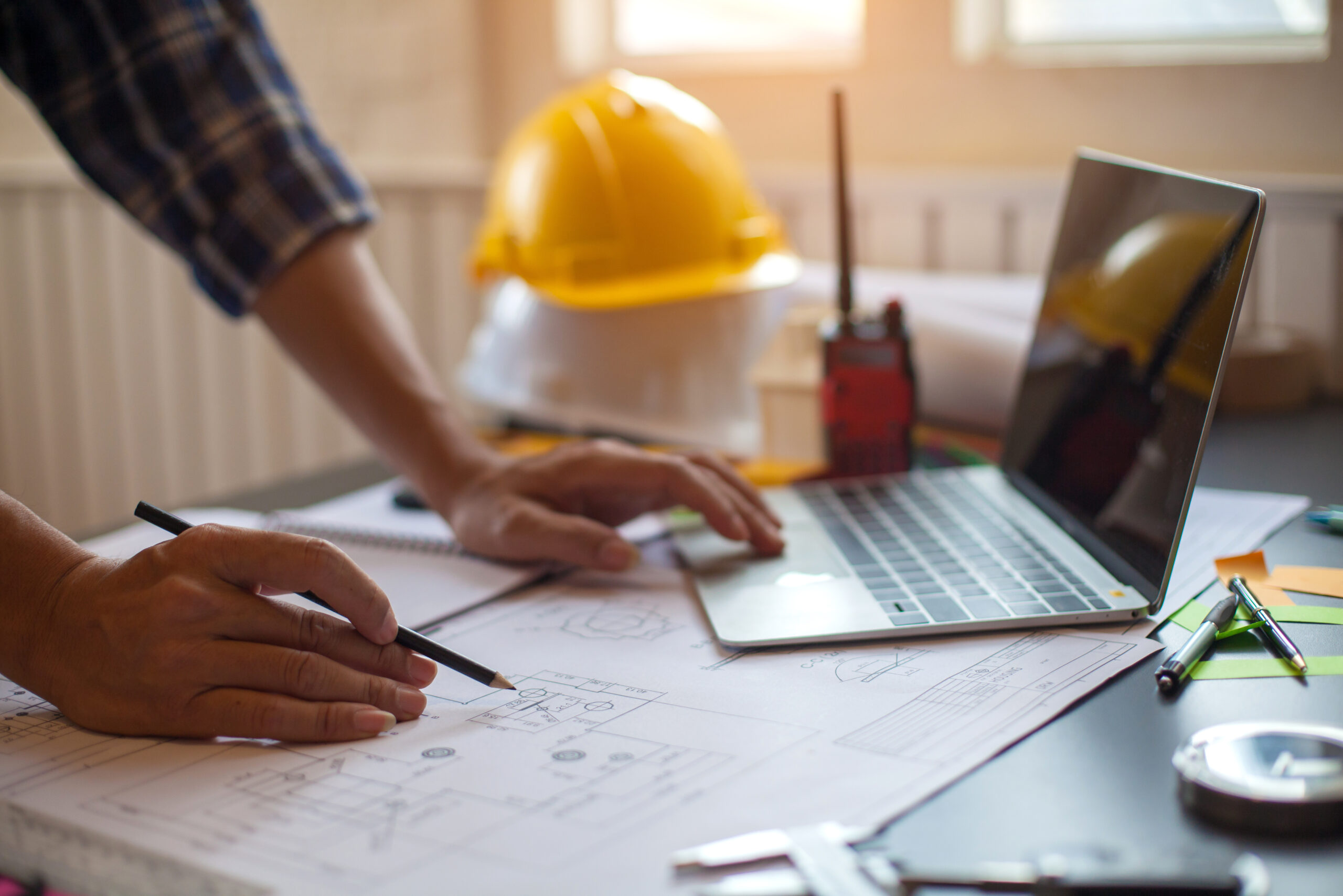 Image of an architect looking over blueprints and planning a construction project budget excel template