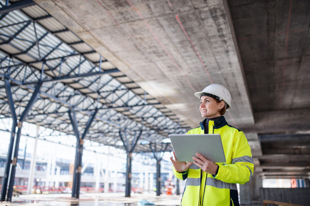 Image of construction workers looking at a finished bridge and a laptop for budget manager software comparisons