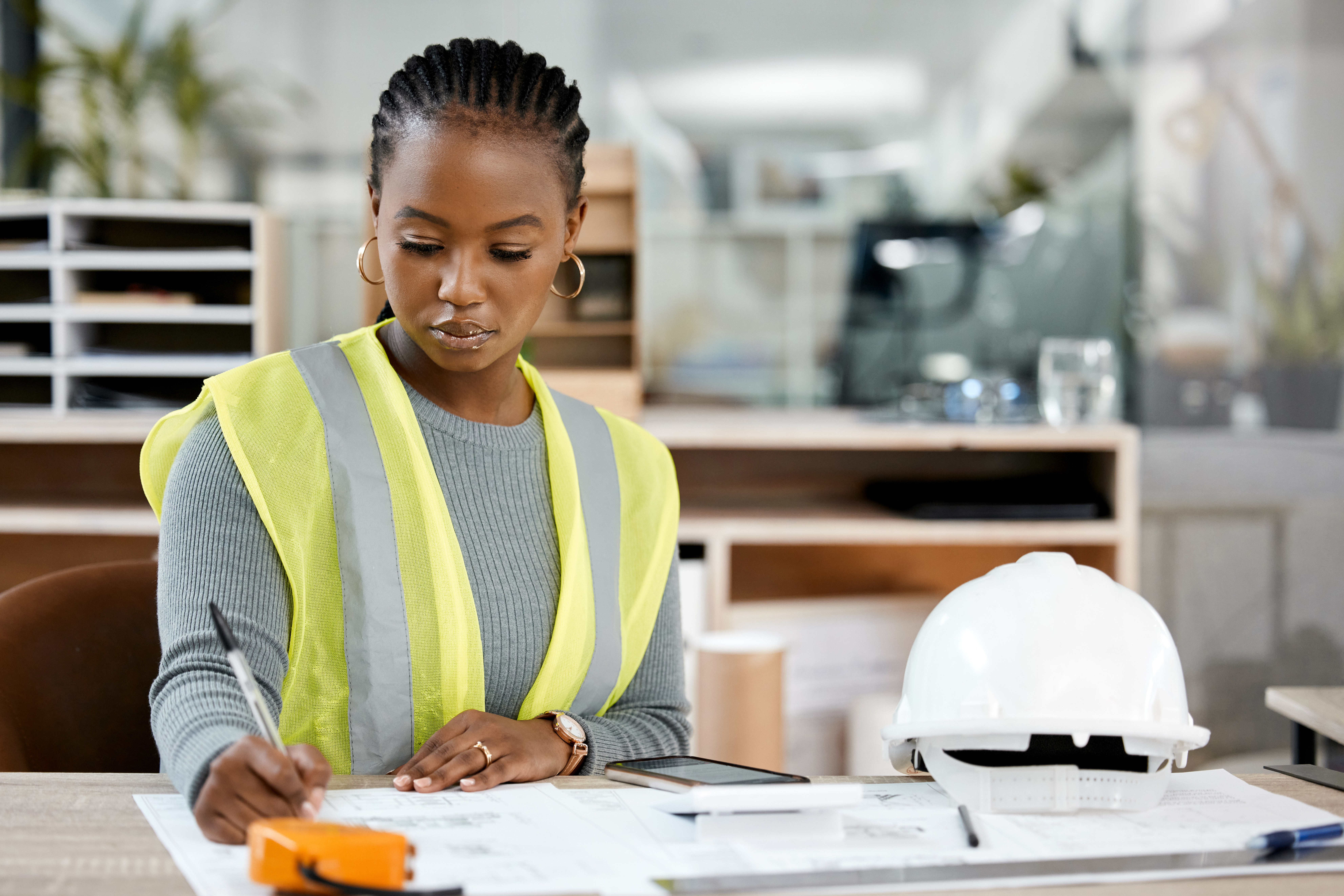 Image of a laptop with various construction equipment around for budget control software