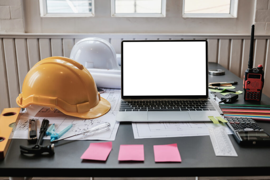 Image of a laptop with various construction equipment around for budget control software