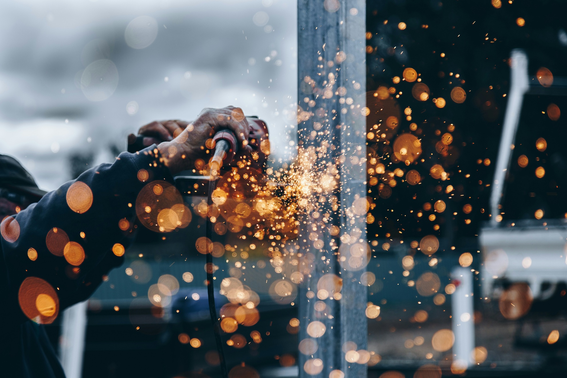 Image of a construction worker using a grinder with sparks flying
