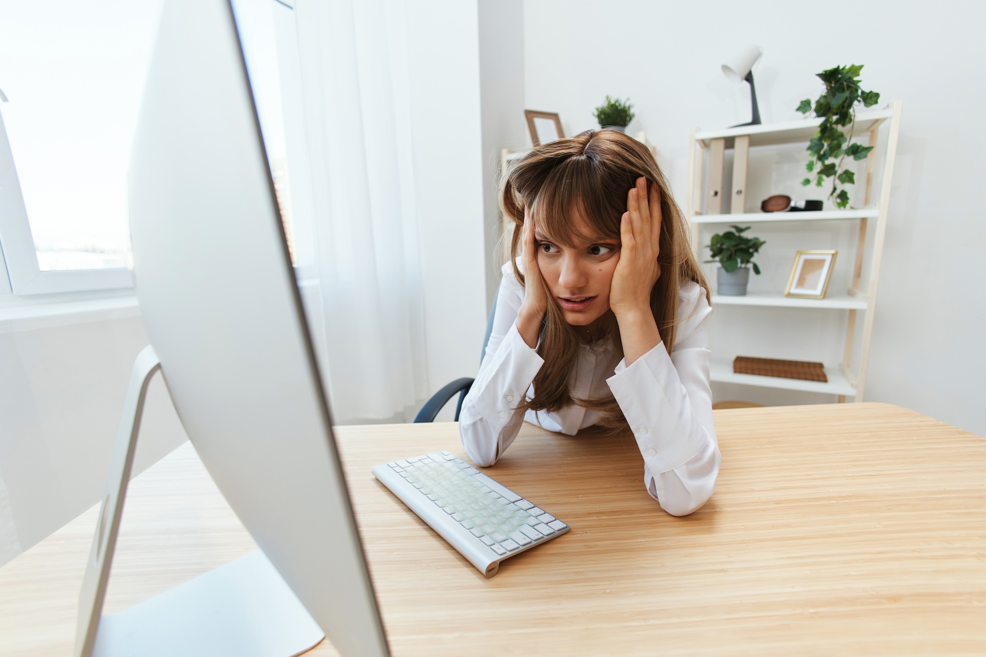 Image of a woman looking frustrated at her computer monitor